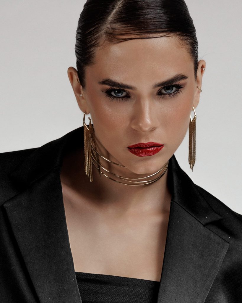 Nahaunfahme von einem Model mit rotem Lippen und goldenen Schmuck auf weißem Studiohintergrund, Fashion Fotografin Vorarlberg