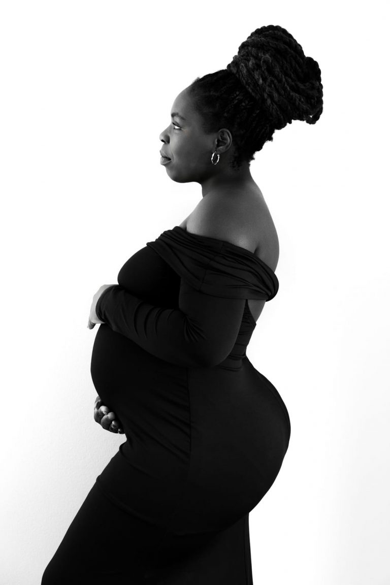 Schwangerschaftsportrait in Schwarz-Weiß mit elegantem Kleid, Babybauch Fotoshooting Vorarlberg.