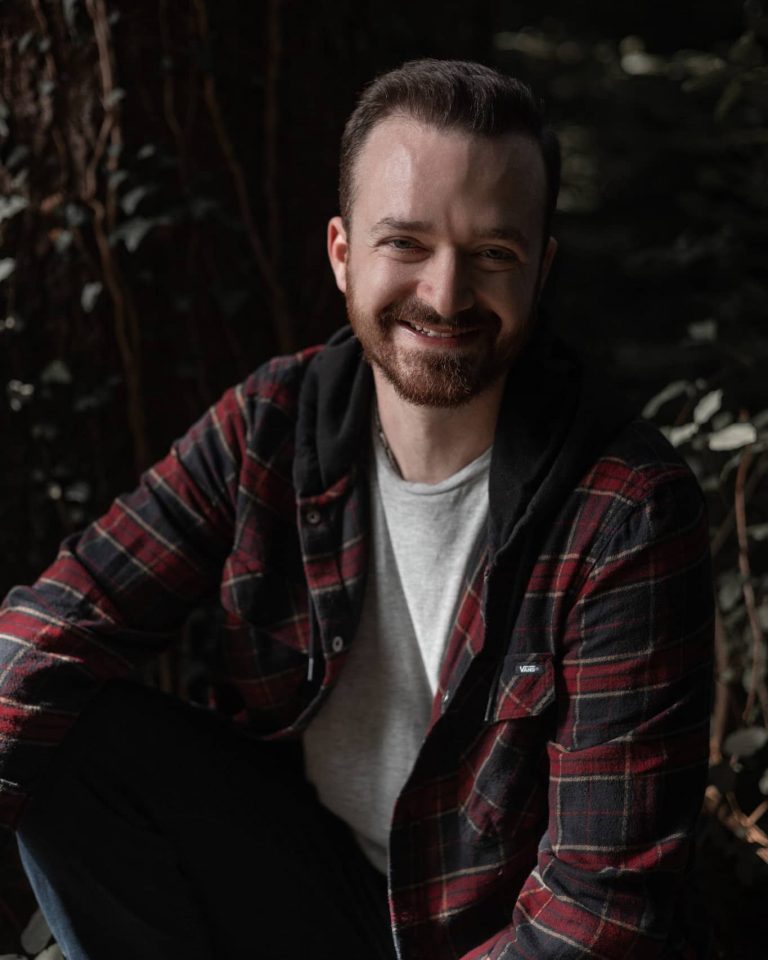 Natürliches Portrait eines Mannes im karierten Hemd im Wald, authentisches Outdoor-Fotoshooting Vorarlberg.