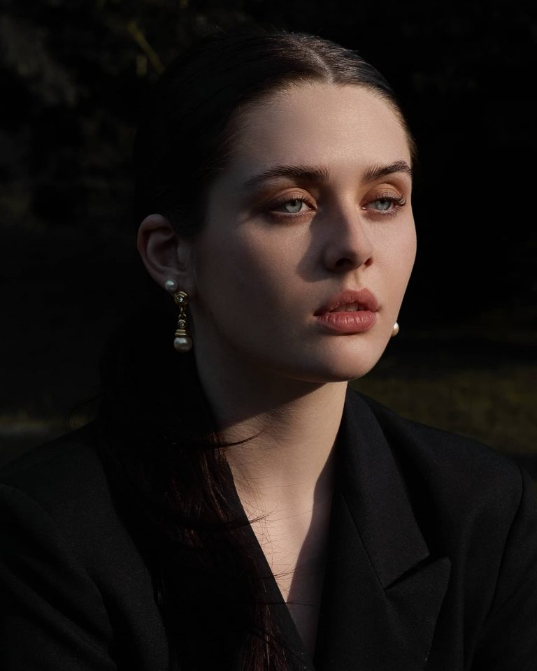 Ausdrucksstarkes Portrait einer Frau mit Perlenohrringen im dunklen Look, Portrait Fotoshooting Vorarlberg.