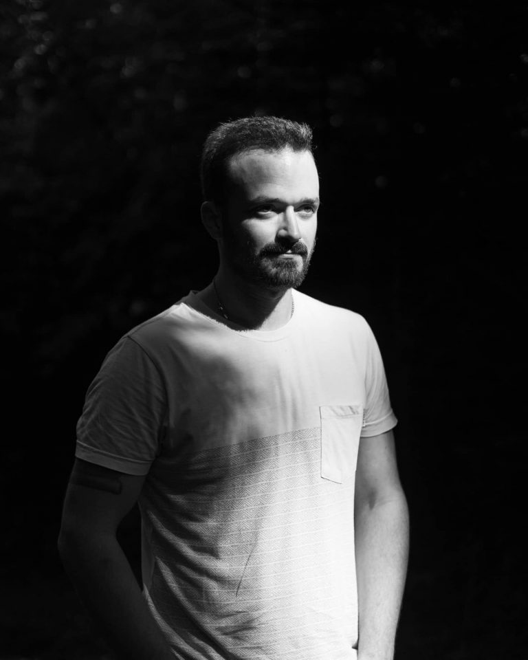 Schwarz-weiß Portrait eines Mannes mit Bart im Sonnenlicht, Portrait Fotoshooting Vorarlberg.