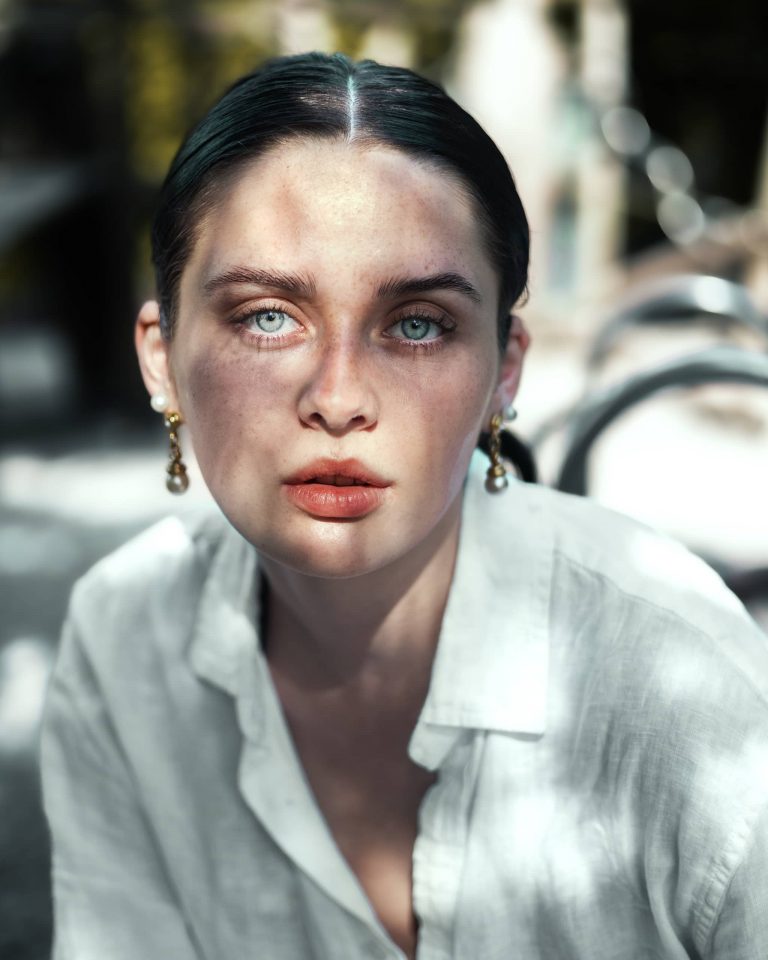 Frau mit hellen Augen und Schattenlicht im Gesicht, Outdoor Portrait Fotoshooting Vorarlberg.