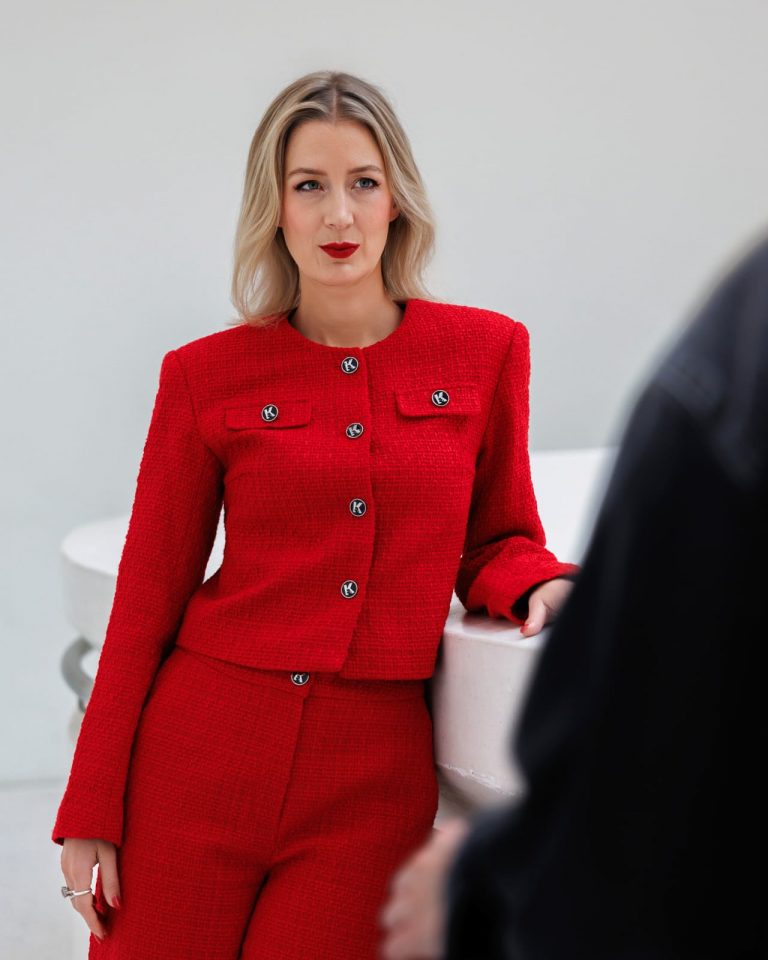 Nahaufnahme einer Frau im roten Anzug mit rotem Lippenstift, stilvolles Business-Portrait Vorarlberg.