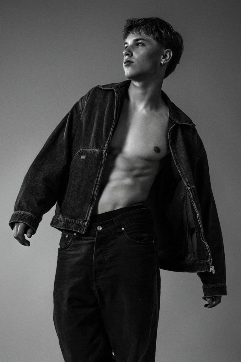 Männliches Model in Schwarz-Weiß beim Sedcardshooting Vorarlberg, mit offener Jeansjacke und Blick in die Ferne – Model Fotoshooting für Sedcardfotos.