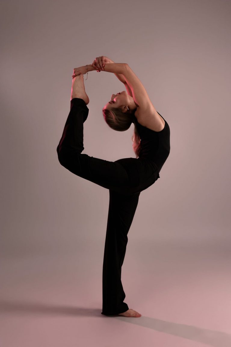 Model in schwarzem Outfit zeigt elegante Yoga-Pose – kreatives Sedcardshooting in Vorarlberg